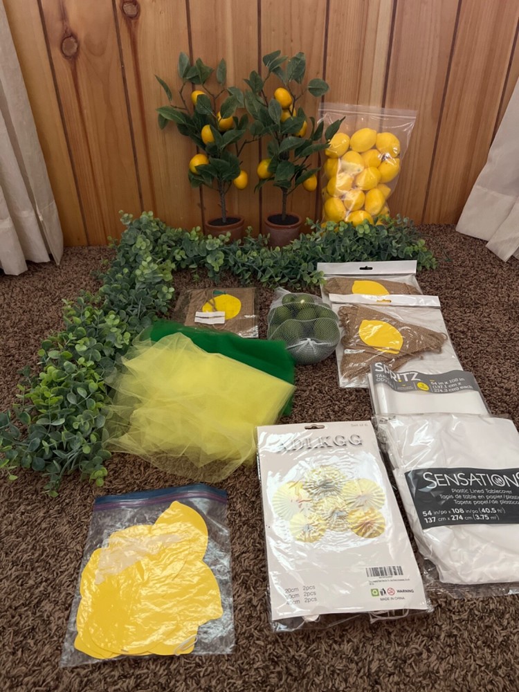 Lemon first birthday decor, garland, paper fans, fake lemons, limes & lemon tree