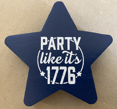 Two “Party Like It’s 1776” wooden star-shaped party decorations